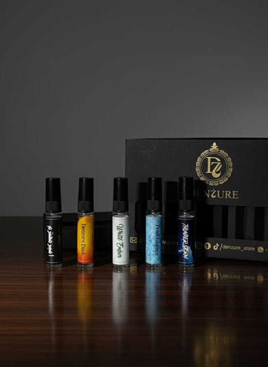 Set of perfume bottles with a branded box on a dark surface