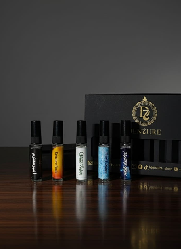 Set of perfume bottles with a branded box on a dark surface